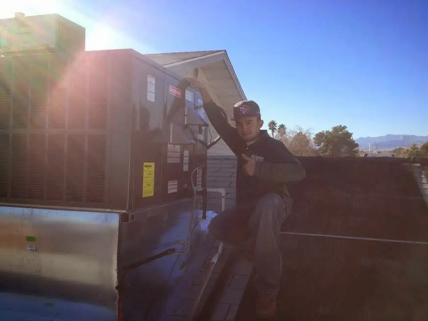 HVAC technician performing AC Tune-Up on a rooftop unit in Shawnee